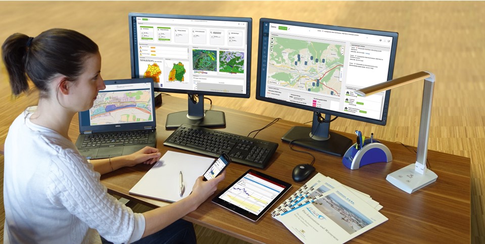 Frau bedient internetbasiertes Flut-Informations- und Warnsystem (FLIWAS)